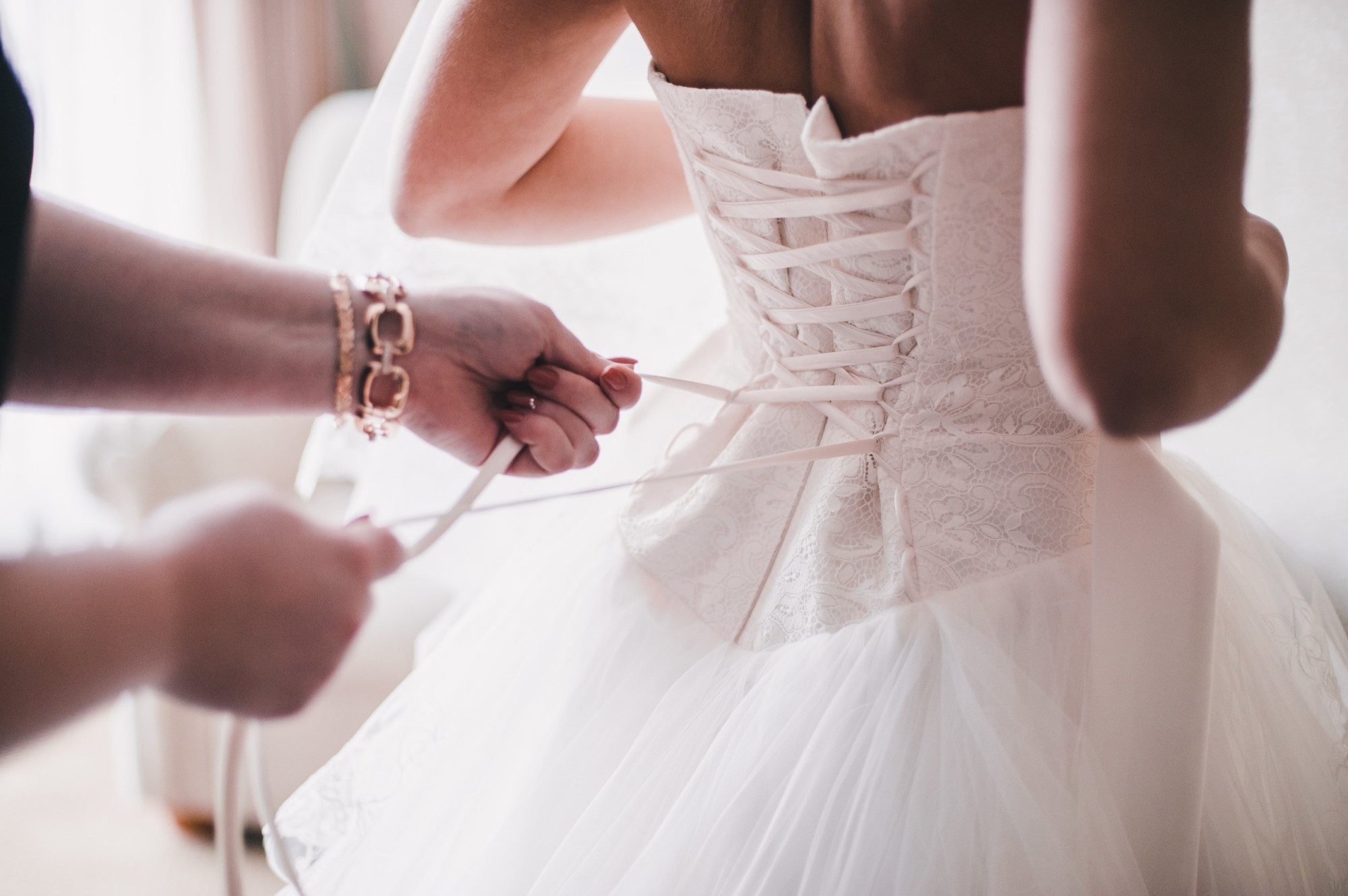 woman tying wedding dress